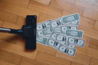 a pile of money sitting on top of a wooden floor by rc.xyz NFT gallery courtesy of Unsplash.