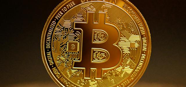 a golden bitcoin sitting on top of a table by Kanchanara courtesy of Unsplash.